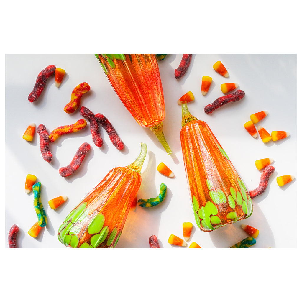 Colorful candy worms and pumpkins on a white background