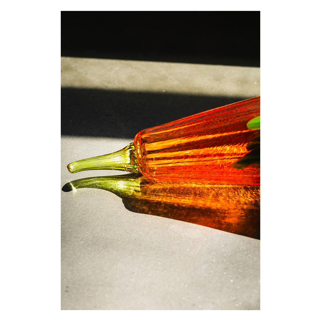 Glass pumpkin with orange and green colors with a colorful shadow 
